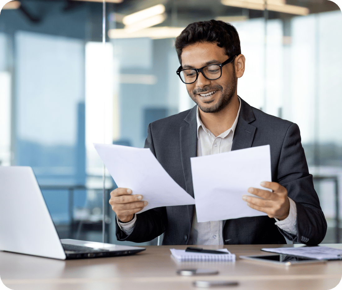 A man in a suit reviews his accounts receivable at his desk