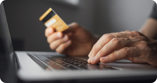 A man uses a credit card to make a payment on his laptop