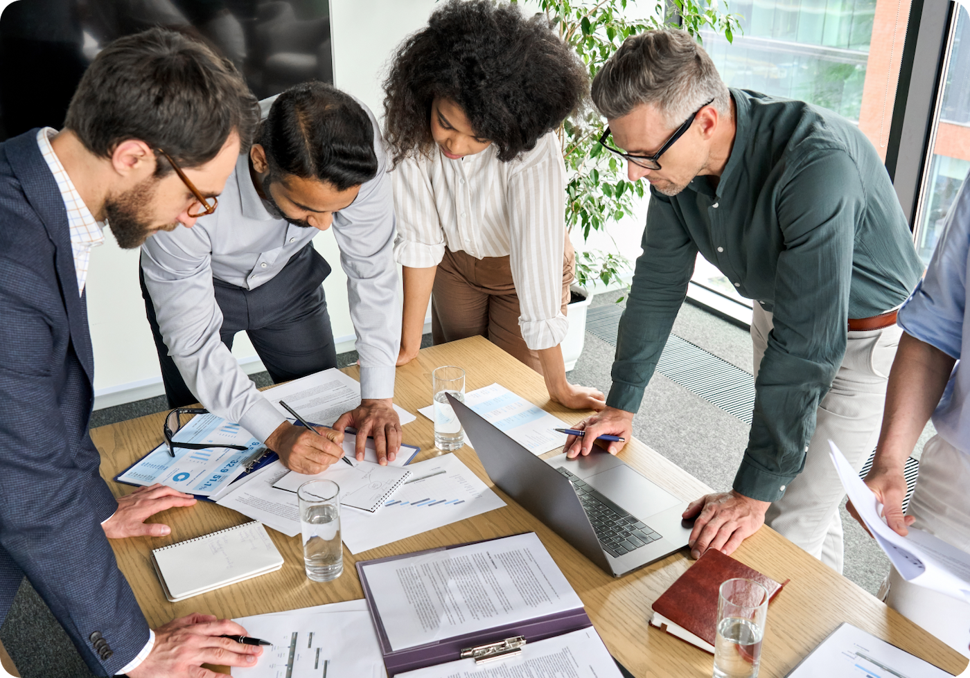 Four coworkers review documentation on a desk