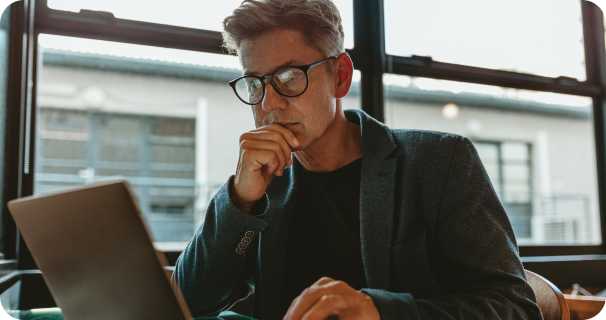 Guy with glasses working on his laptop in an office